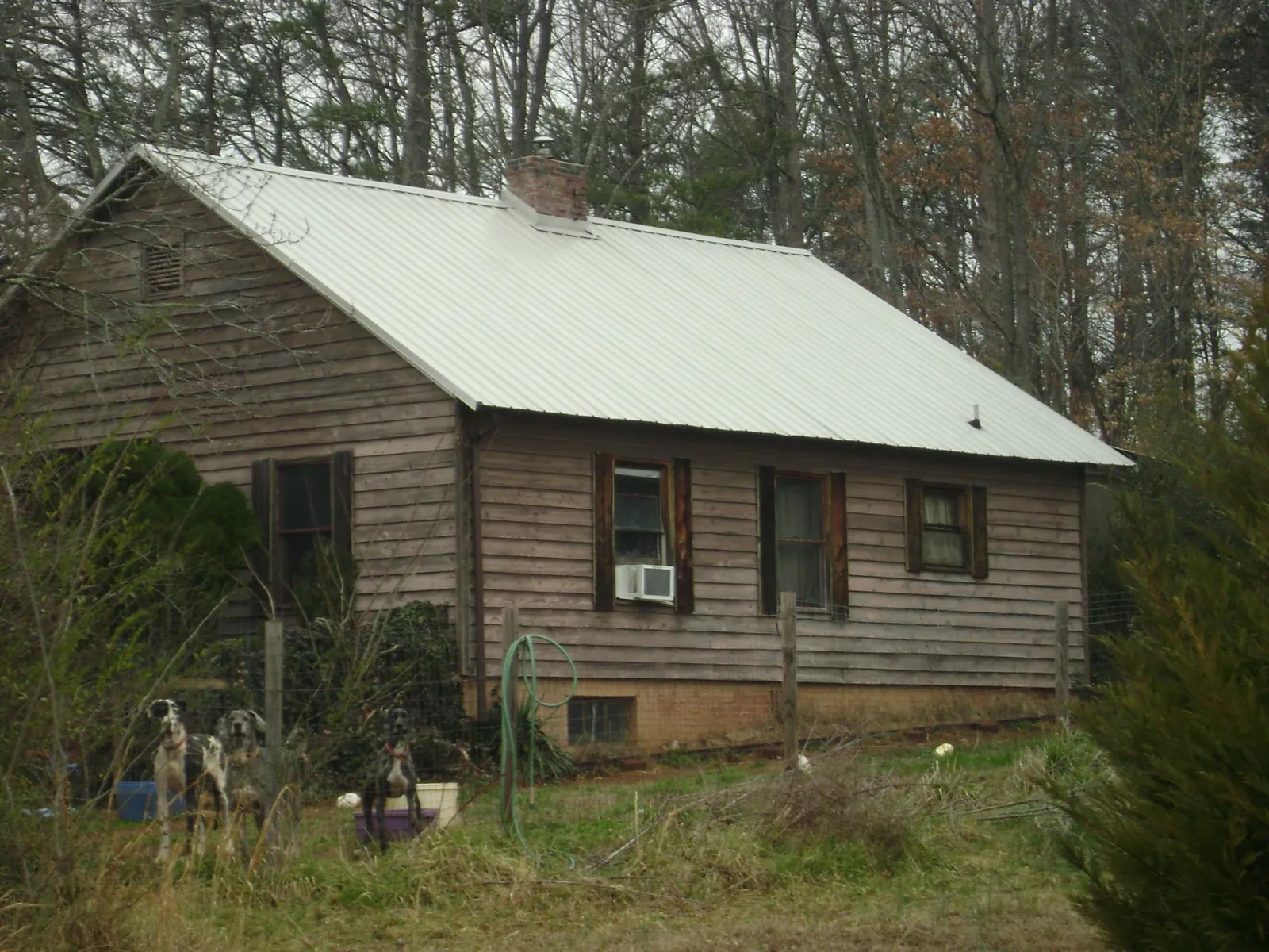 White metal roof on an old wood sided farmhouse, from a Metal Roof Installation job in Laurel